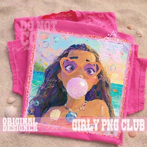 May include: A pink t-shirt featuring a colorful, impressionistic portrait of a person wearing heart-shaped glasses and blowing a bubble. The artwork has a beach theme with seashells and a tropical landscape. The text "GIRLY PNG CLUB" is visible.
