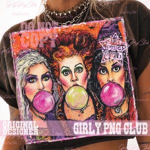 May include: A dark brown t-shirt featuring a graphic print of three women with stylized hair and makeup, each blowing a large bubble with gum. The print includes a star shape with the text GIRLY PNG CLUB and an orange and pink background.