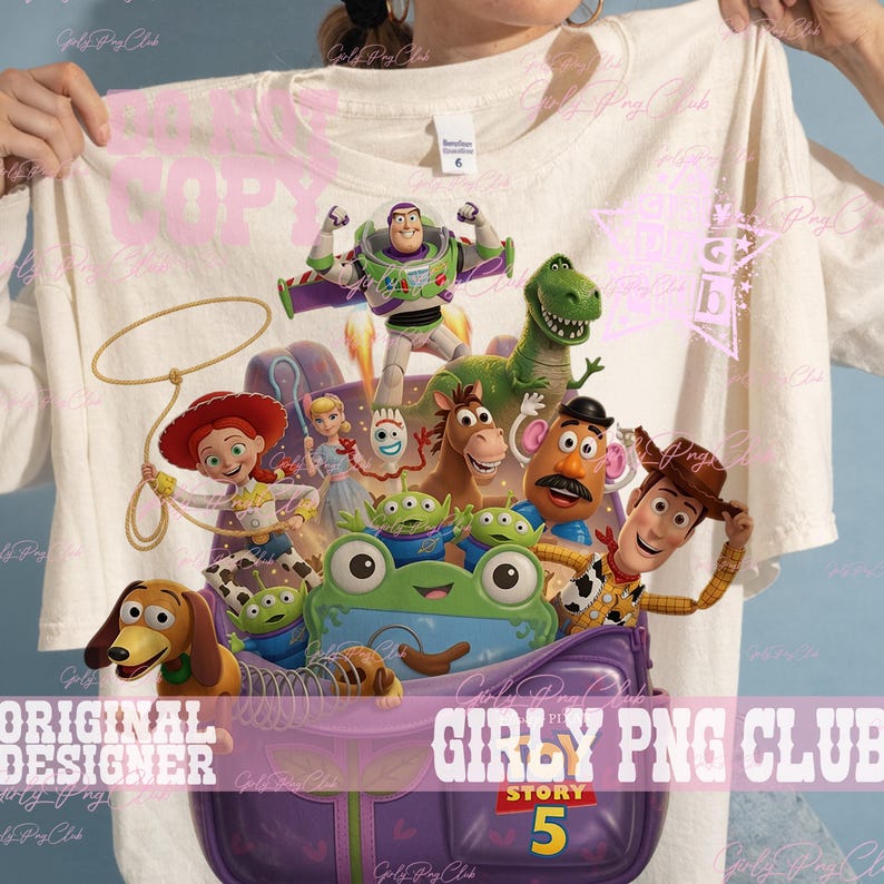 Puede incluir: Una camiseta de color crema con un estampado gr&aacute;fico de personajes de Toy Story, incluidos Buzz Lightyear, Woody, Jessie, Rex, el Sr. Patata, Slinky Dog y alien&iacute;genas saliendo de una mochila morada. El texto dice Story 5.