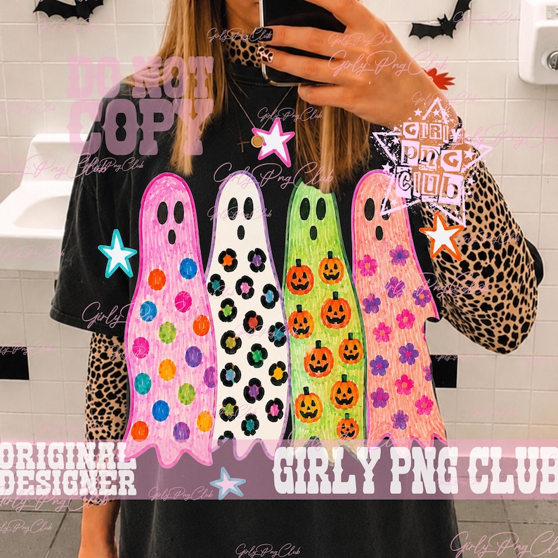May include: A black short-sleeve t-shirt worn over a leopard print long-sleeve shirt. The t-shirt features a graphic of four ghosts in pink, white, green, and orange, decorated with colorful polka dots, leopard spots, pumpkins, and flowers.