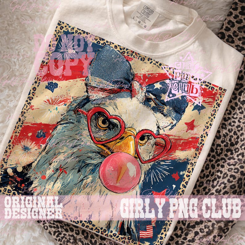 May include: Cream-colored t-shirt featuring a patriotic eagle design. The eagle wears heart-shaped glasses and a bow, blowing a bubblegum bubble. The design includes red, white, and blue elements, fireworks, and the text "Girly PNG Club."