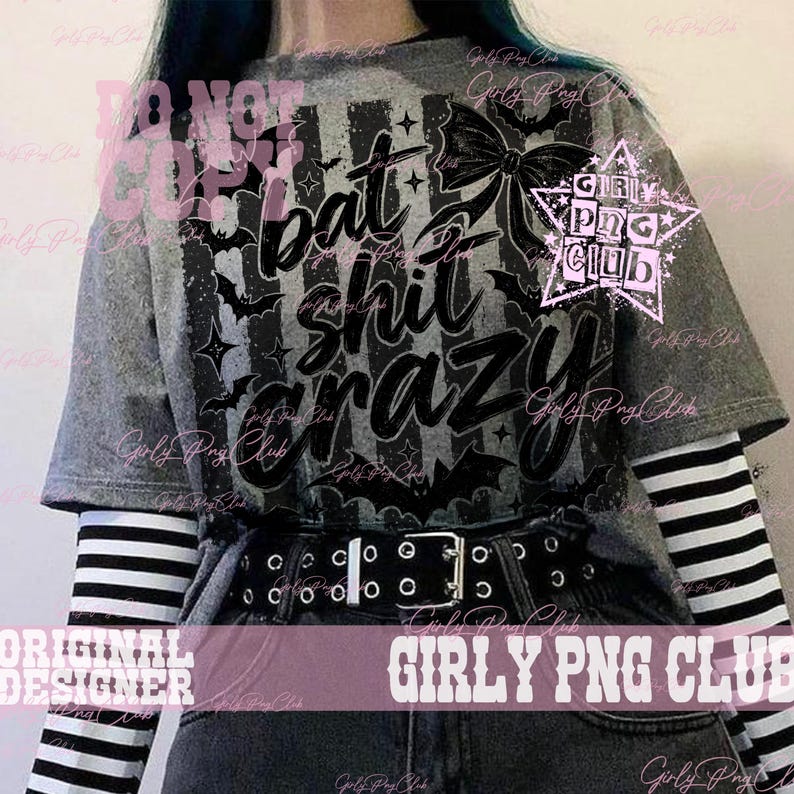 May include: A heather gray short-sleeve t-shirt featuring a black graphic print of bats, stars, a bow, and the text "bat shit crazy" in a stylized script font. The shirt is layered over a long-sleeve black and white striped shirt and a black belt.