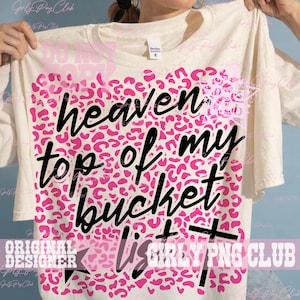 Peut inclure: T-shirt cr&egrave;me avec un motif l&eacute;opard rose et l'inscription noire "heaven top of my bucket list". Le t-shirt est de style d&eacute;contract&eacute;.