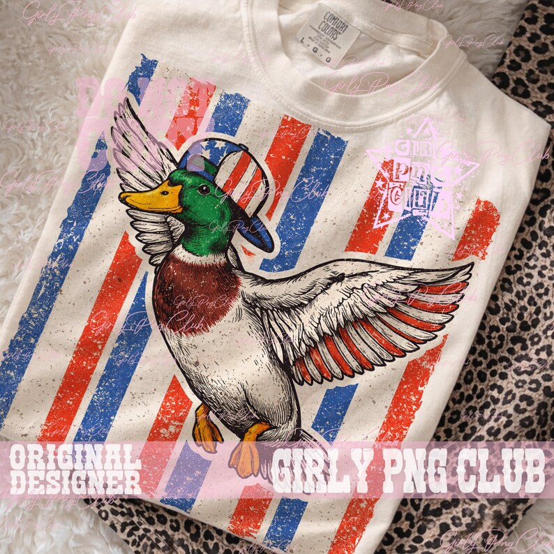 Pu&ograve; includere: Maglietta a maniche lunghe color crema con una grafica di un'anatra con un cappello con un disegno della bandiera americana. L'anatra ha piume verdi, marroni e bianche. La maglietta ha strisce rosse e blu sullo sfondo. Il testo "GIRLY PNG CLUB" &egrave; visibile.