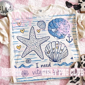 May include: Cream-colored t-shirt with a blue and white nautical design. The design includes a starfish, seashells, hearts, and the text "I need vitaGIRLS PNG CLUB". The shirt has short sleeves.