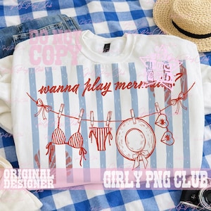 Op de afbeelding: Witte sweatshirt met een rood en blauw ontwerp. De afbeelding bevat een bikini, een zonnehoed en de tekst "wanna play mermaids?" Het ontwerp heeft een strandthema.