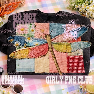 May include: Dark gray sweatshirt featuring a colorful patchwork dragonfly design. The dragonfly has wings in shades of blue, pink, and yellow. The shirt also has the text "DO NOT COPY" and "GIRLY PNG CLUB".