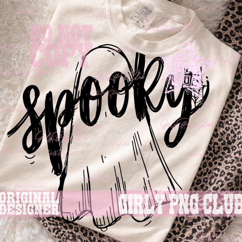 Puede incluir: Una camiseta de manga corta de color crema con un gr&aacute;fico negro de un fantasma y la palabra SPOOKY escrita en una fuente estilizada, negrita y manuscrita en el centro. La camiseta tiene cuello redondo y una etiqueta de marca visible.