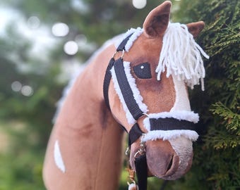 May include: A brown and white plush horse head with a black halter and lead rope. The horse has a white mane and tail.