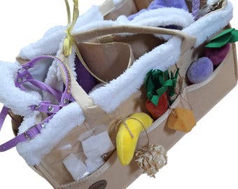 May include: A beige felt tote bag with a zipper closure and multiple pockets. The bag is filled with various plush toys, including a purple stuffed animal, a yellow banana, and a green and red carrot. The bag also contains a white stuffed animal, a yellow ribbon, and a purple and white shoe.