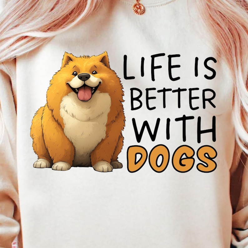 May include: White sweatshirt featuring a cartoon dog with orange fur and a smiling expression. The text "LIFE IS BETTER WITH DOGS" is printed in black and orange. The sweatshirt has a crew neck.