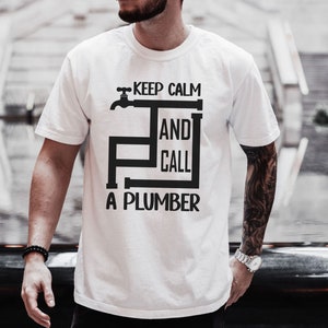 May include: White t-shirt with a black graphic that says "Keep Calm and Call a Plumber". The graphic features a stylized faucet and pipes.