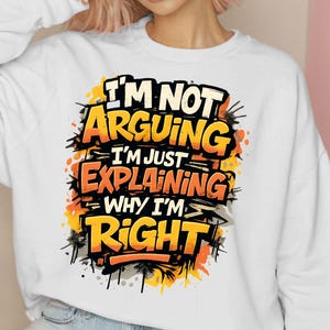 Pu&ograve; includere: Felpa bianca con la scritta "I'M NOT ARGUING I'M JUST EXPLAINING WHY I'M RIGHT" in un design in stile graffiti. Il testo &egrave; in bianco, arancione e giallo con accenti neri. La felpa &egrave; di stile casual.