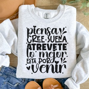 May include: Gray sweatshirt with black text that reads "piensa cree sue&ntilde;a atrevete lo mejor esta por venir".