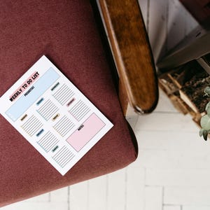 May include: A white weekly to-do list with a light blue, pink, and yellow color scheme. The list is divided into sections for priorities, Monday, Tuesday, Wednesday, Thursday, Friday, Saturday, and Sunday. There is a notes section at the bottom.