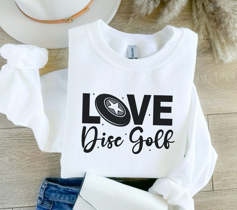 May include: White sweatshirt with black text that reads "LOVE Disc Golf" and a black disc golf disc with a white star in the center.
