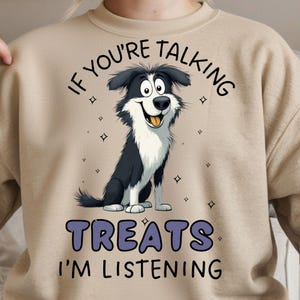 May include: Beige sweatshirt with a cartoon illustration of a black and white Border Collie dog. The text above the dog reads "IF YOU'RE TALKING" and below the dog it says "TREATS I'M LISTENING".