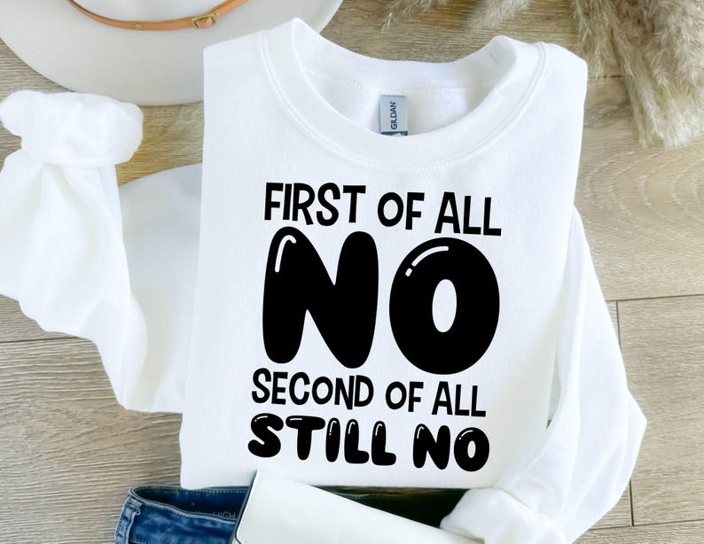 K&ouml;nnte beinhalten: Wei&szlig;er Pullover mit schwarzem Text, der "First of all NO Second of all STILL NO" lautet.