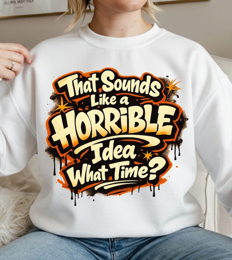 Pu&ograve; includere: Felpa bianca con la scritta "That Sounds Like a Horrible Idea What Time?" in lettering arancione e nero in stile graffiti. Il design include stelle e effetti di vernice gocciolante.