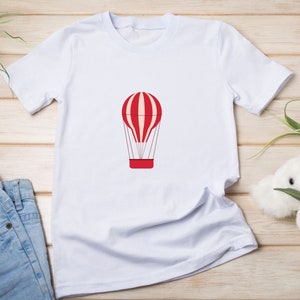 May include: White t-shirt with a red and white striped hot air balloon graphic.