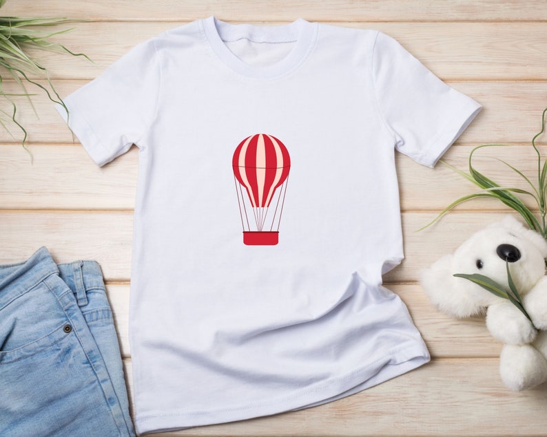 May include: White t-shirt with a red and white striped hot air balloon graphic.