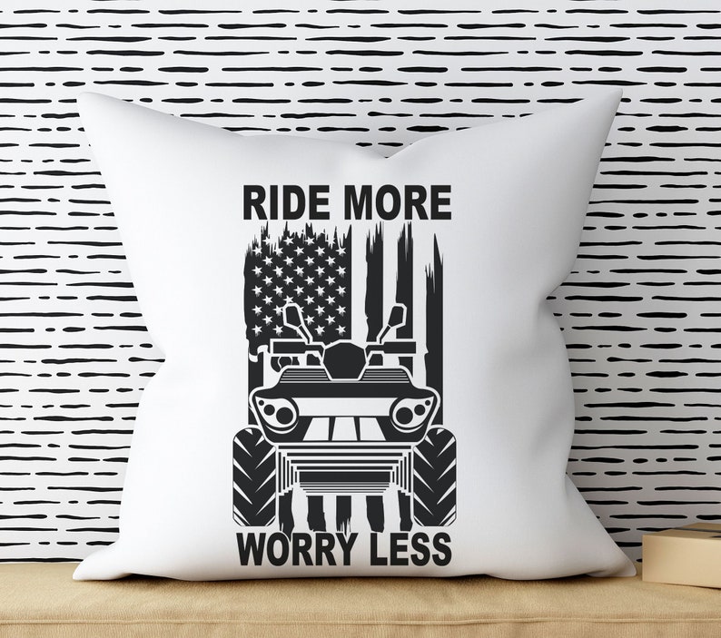 May include: White pillow with a black and white graphic of an ATV with an American flag in the background. The text "Ride More Worry Less" is printed below the ATV.