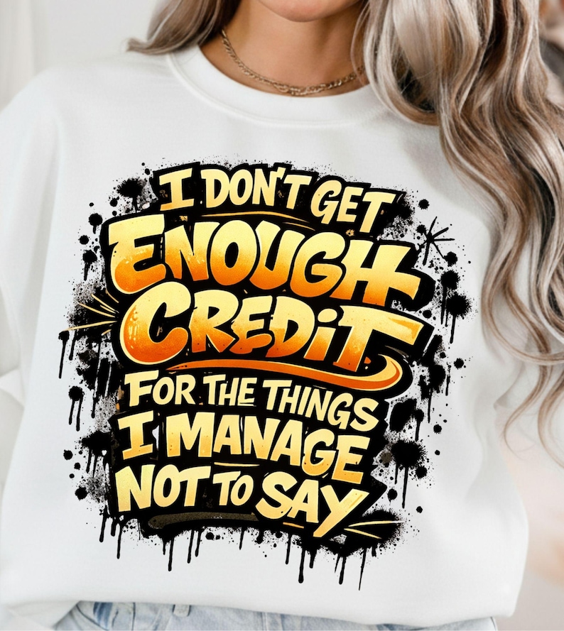 Pu&ograve; includere: Felpa bianca con la scritta "I DON'T GET ENOUGH CREDIT FOR THE THINGS I MANAGE NOT TO SAY" in giallo e arancione, con schizzi e gocce neri.
