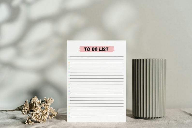 May include: A white to-do list with a pink "TO DO LIST" banner at the top. The list has black lines for writing and colorful dots on the left side.