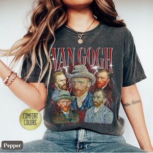 Może przedstawiać: Szary t-shirt z nadrukiem w stylu vintage przedstawiającym autoportret Vincenta van Gogha i inne obrazy. Tekst "Van Gogh" jest nadrukowany na koszulce na czerwono i biało. Koszulka ma postarzony wygląd i wygodny kr&oacute;j.