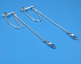 May include: A pair of silver dangle earrings with a chain and a small, twisted, leaf-shaped pendant.