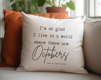 May include: White throw pillow with black text that reads "I'm so glad I live in a world where there are Octobers -Anne of Green Gables".
