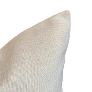 May include: Close-up of the corner of a white pillow with a textured fabric.