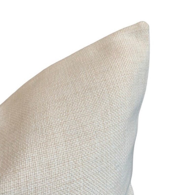 May include: Close-up of the corner of a white pillow with a textured fabric.