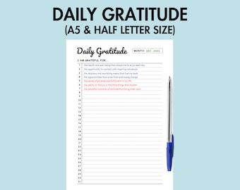 May include: A printable daily gratitude journal with a blue pen. The journal has a white background with black lines and a header that says "Daily Gratitude (A5 & Half Letter Size)". The journal has a section for the month and year, which is "Dec. 2023". The journal has a list of 31 numbered lines for writing down things you are grateful for.