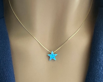 May include: A delicate gold chain necklace with a small blue star-shaped pendant.