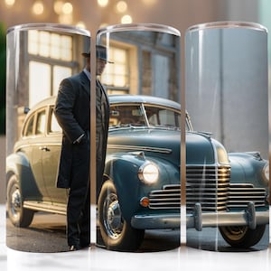 May include: A vintage blue car with chrome accents and a man in a suit and fedora standing next to it. The car has a long hood and a large grille. The man is looking at the camera.