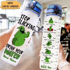 May include: Two clear water bottles with blue lids. One bottle has the text "STOP SLACKING DRINK YOUR WATER Your Name" and a green cartoon character. The other bottle has a water intake guide.