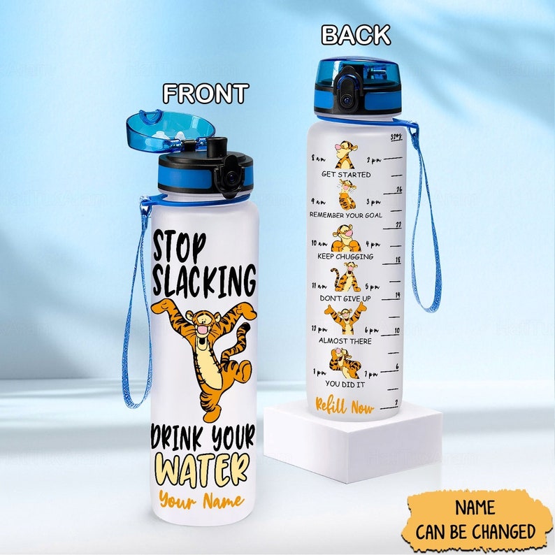 May include: A white water bottle with a blue lid and strap. The front of the bottle features a cartoon tiger with the text "Stop Slacking" and "Drink Your Water". The back of the bottle has a motivational quote and a measurement scale with times from 8 am to 1 pm. The text "Name Can Be Changed" is at the bottom of the image.