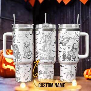 May include: Three white stainless steel tumblers with black and white illustrations of characters from Tim Burton's The Nightmare Before Christmas. The tumblers feature Jack Skellington, Sally, and other characters from the film. The text "Jack & Sally" and "Tim Burton's The Nightmare Before Christmas" is printed on the tumblers. The tumblers have a straw and a lid.