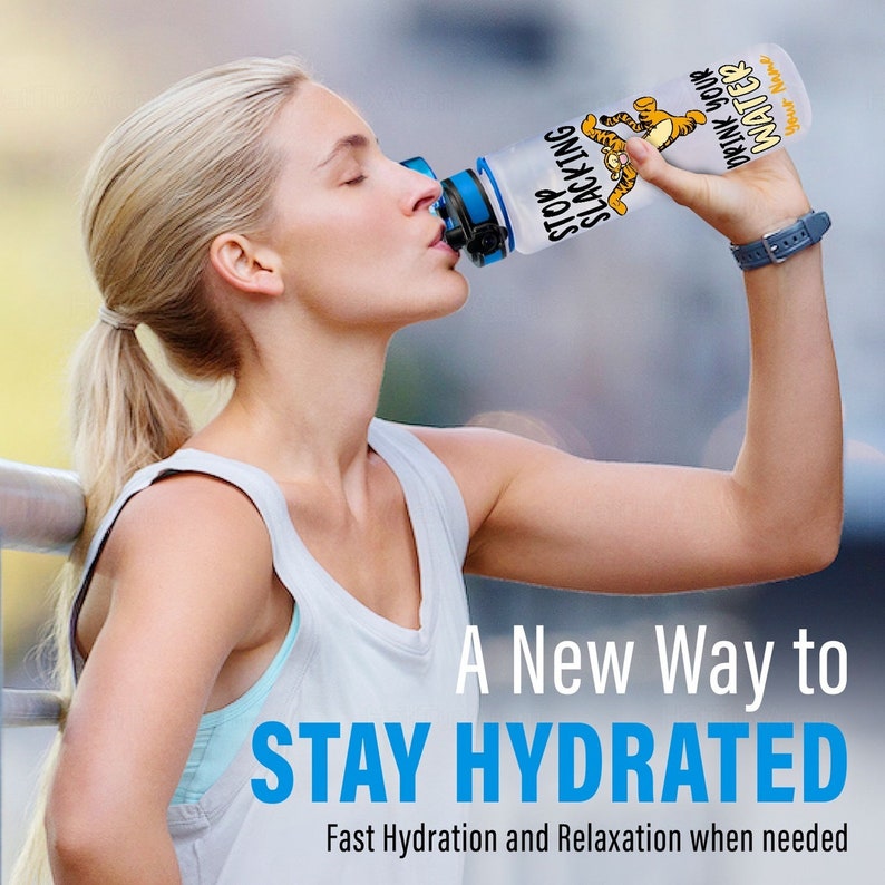 May include: A clear water bottle with a blue lid and a cartoon tiger graphic. The bottle has the text "Stop Slacking Drink Your Water" on it. A woman is drinking from the bottle. A new way to stay hydrated. Fast hydration and relaxation when needed.