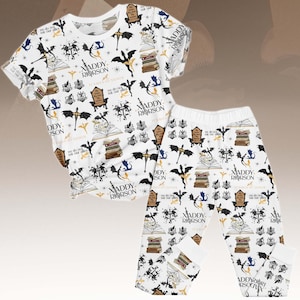 May include: White pajama set featuring a repeating pattern of dragons, books, chairs, and text. The text includes "Xaddy Riorrson" and "we do not eat our lies". The set includes a short-sleeved top and trousers.