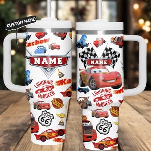 Puede incluir: Vaso blanco con un diseño que presenta a Rayo McQueen y otros personajes de Cars. El diseño incluye el texto "NAME", "Lightning McQueen 95", "Route 66" y "Kachow". El vaso tiene un asa y una tapa blancas.