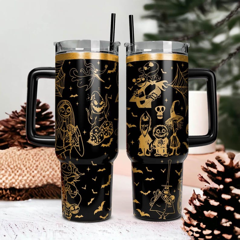 May include: Two black stainless steel tumblers with gold-colored designs of characters from the Nightmare Before Christmas. The tumblers have lids and handles.