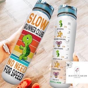 Op de afbeelding: Een witte waterfles met een blauwe dop en een retro-ontwerp met een schildpad en de tekst "Slow Runner Club No Need For Speed". De fles heeft een motiverende tracker met tijden en tekst zoals "Get Started", "Member Your Goal", "Keep Chugging", "Don't Give Up", "Almost There", "You Did It", en "Refill Now".