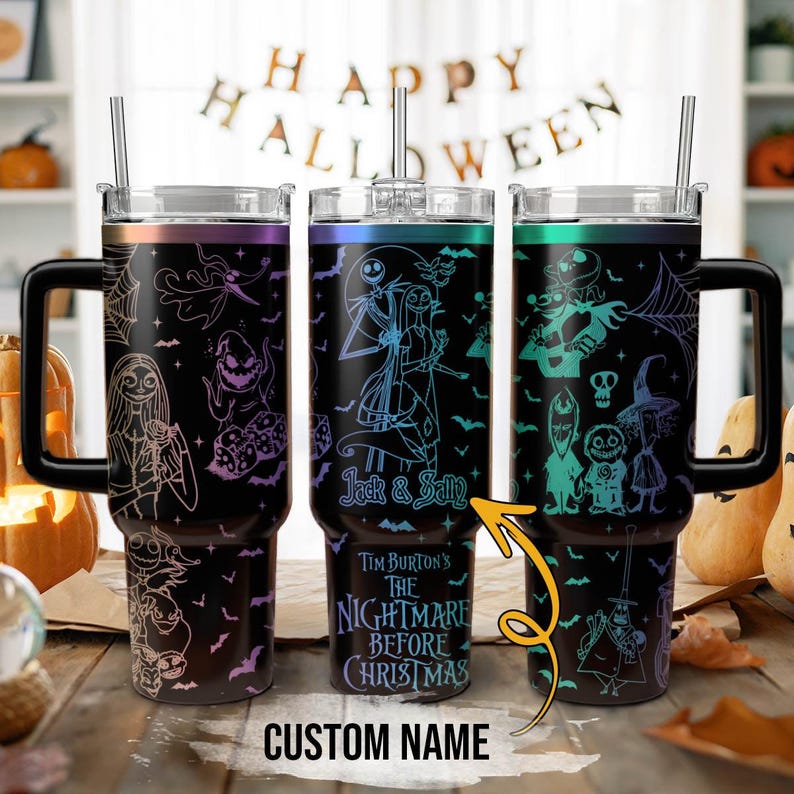 May include: Three black stainless steel tumblers with lids and straws. Each tumbler features a different design from Tim Burton's The Nightmare Before Christmas. The designs include Jack Skellington, Sally, and other characters from the film. The text "Jack & Sally" and "Tim Burton's The Nightmare Before Christmas" are visible on the tumblers. The tumblers are on a wooden surface.