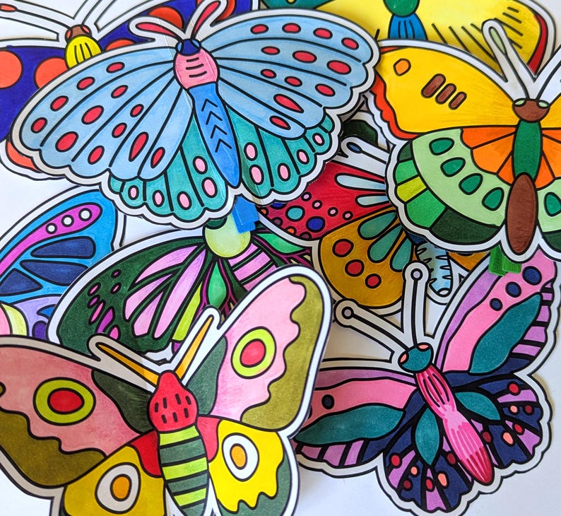 May include: A collection of colorful, hand-drawn butterfly stickers. The butterflies feature a variety of designs with vibrant colors including blue, pink, yellow, and green. Each butterfly has a black outline, and the stickers are arranged in a layered composition.