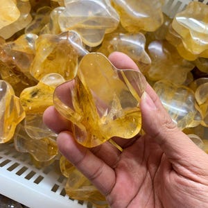 Könnte beinhalten: Eine weiße Keramik-Tasse mit schwarzem Henkel und dem Text "But first, coffee" in handschriftlichem Stil. Die Tasse steht auf einer weißen Oberfläche. Die Tasse ist etwa 10 cm hoch.