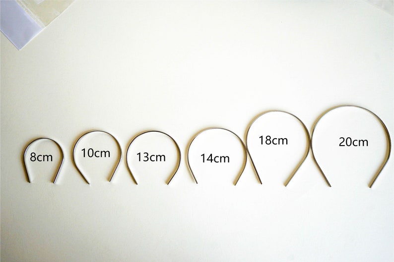 Pu&ograve; includere: Sei cerchietti in metallo argentato di diverse dimensioni, etichettati con le loro misure in centimetri: 8 cm, 10 cm, 13 cm, 14 cm, 18 cm e 20 cm.