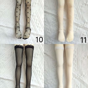 Pode incluir: Quatro pares de meias para bonecas em preto e branco. As meias t&ecirc;m padr&otilde;es diferentes, incluindo losangos, listras e lisas. As meias s&atilde;o exibidas em um fundo branco.