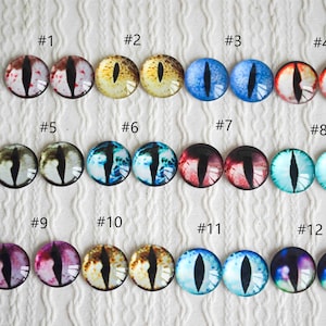 Pode incluir: Doze pares de olhos de vidro com diferentes cores e padrões, incluindo vermelho, azul, verde, amarelo e roxo. Cada olho é etiquetado com um número de 1 a 12.